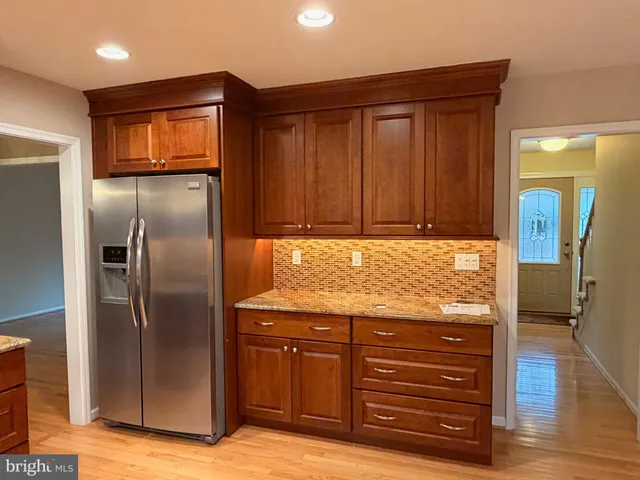a view of cabinets with refrigerator and wooden floor