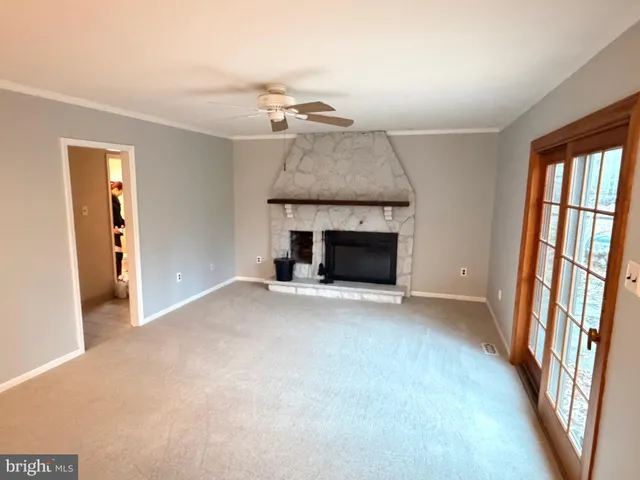 a view of an empty room with a fireplace and a window