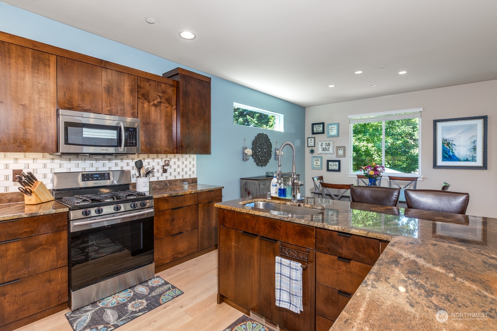 4408 Forest Drive Everett, WA 98203 - Photo 9 of 32 a kitchen with a stove a sink a microwave a dining table and chairs