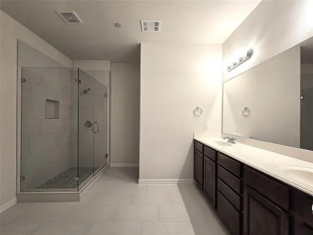 a spacious bathroom with a shower sink and mirror