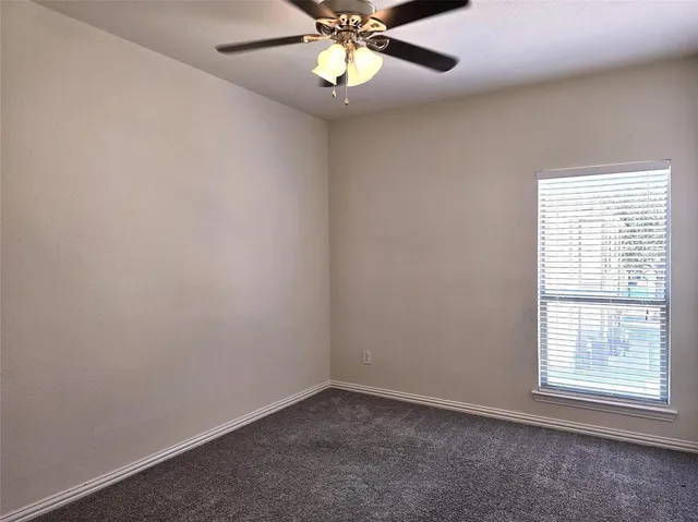 an empty room with window and chandelier fan