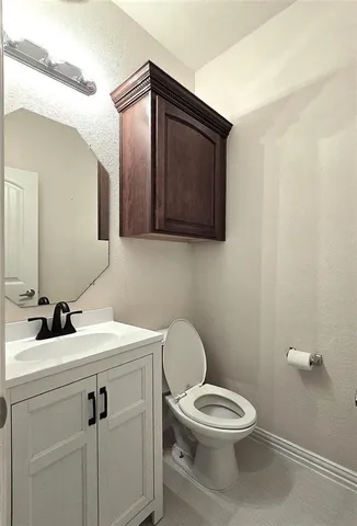 a bathroom with a toilet a sink and mirror