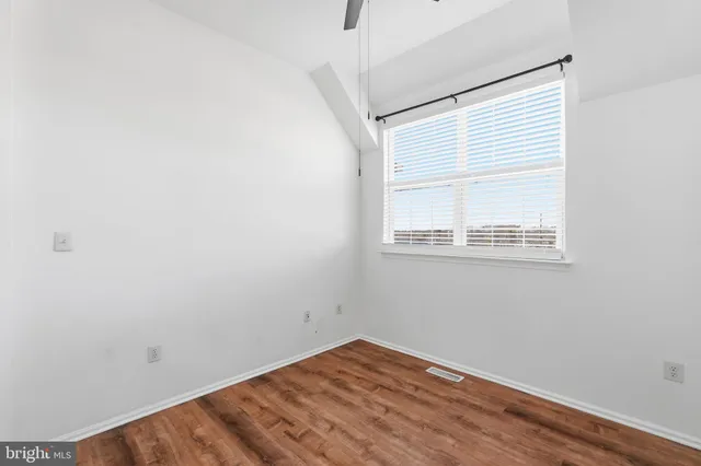 a view of a small space with wooden floor and a window