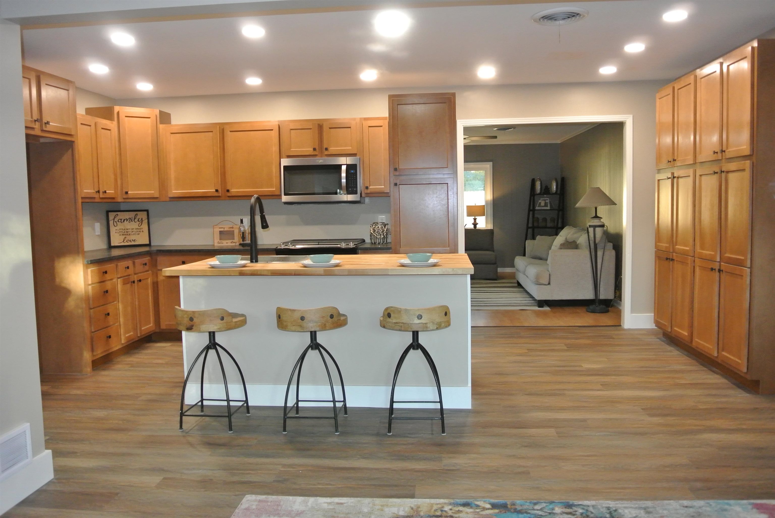 a kitchen with stainless steel appliances kitchen island granite countertop a refrigerator and microwave