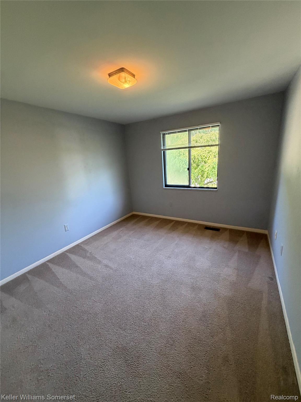 3277 Eastern Avenue Rochester, MI 48307 - Photo 7 of 13 Carpeted room featuring light blue walls and a window with exterior tree scenery