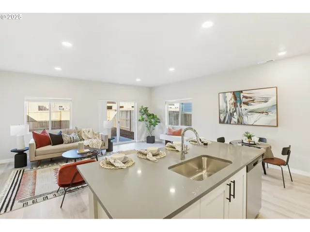 a living room with furniture a flat screen tv and kitchen view