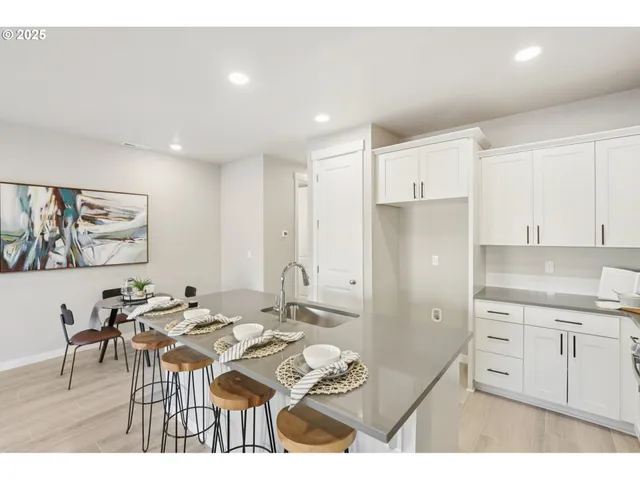 a kitchen with stainless steel appliances kitchen island granite countertop a refrigerator a stove a sink dishwasher with a dining table and chairs