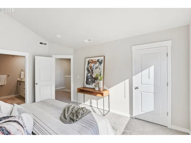 a bedroom with a bed and a painting on the wall