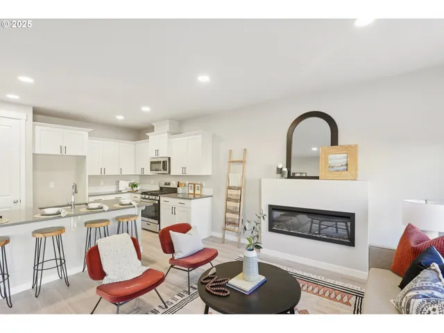 a living room with furniture a fireplace and kitchen view