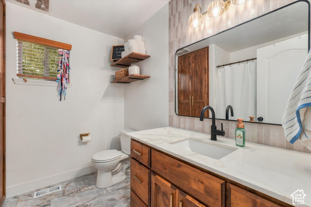 437 Scenic Heights Road Kamas, UT 84036 - Photo 16 of 46 Wood-finish vanity with a white countertop and integrated rectangular sink