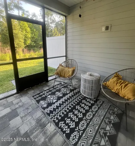 a living room with furniture and a floor to ceiling window