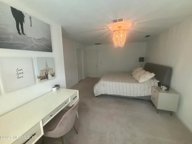 a living room with lots of chairs and kitchen view