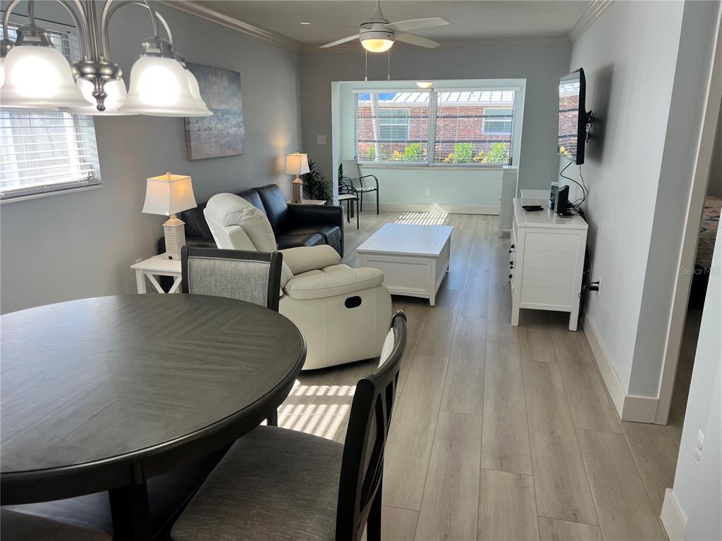 6020 Midnight Pass Road, Unit 32 Sarasota, FL 34242 - Photo 2 of 13 a living room with couches and a dining table with wooden floor