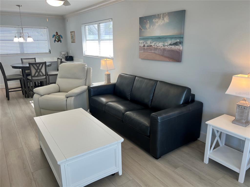 6020 Midnight Pass Road, Unit 32 Sarasota, FL 34242 - Photo 4 of 13 a living room with furniture and a wooden floor