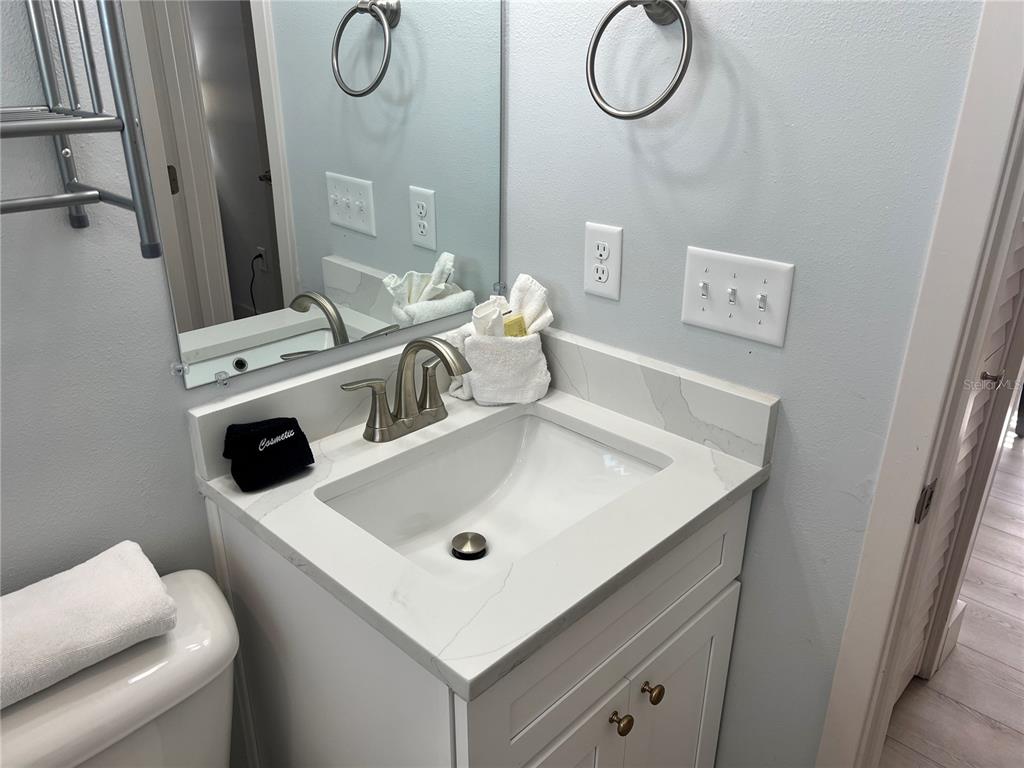 6020 Midnight Pass Road, Unit 32 Sarasota, FL 34242 - Photo 9 of 13 a bathroom with a sink and mirror