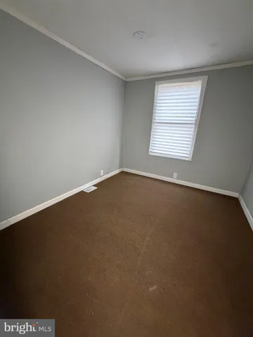 an empty room with a ceiling fan and window