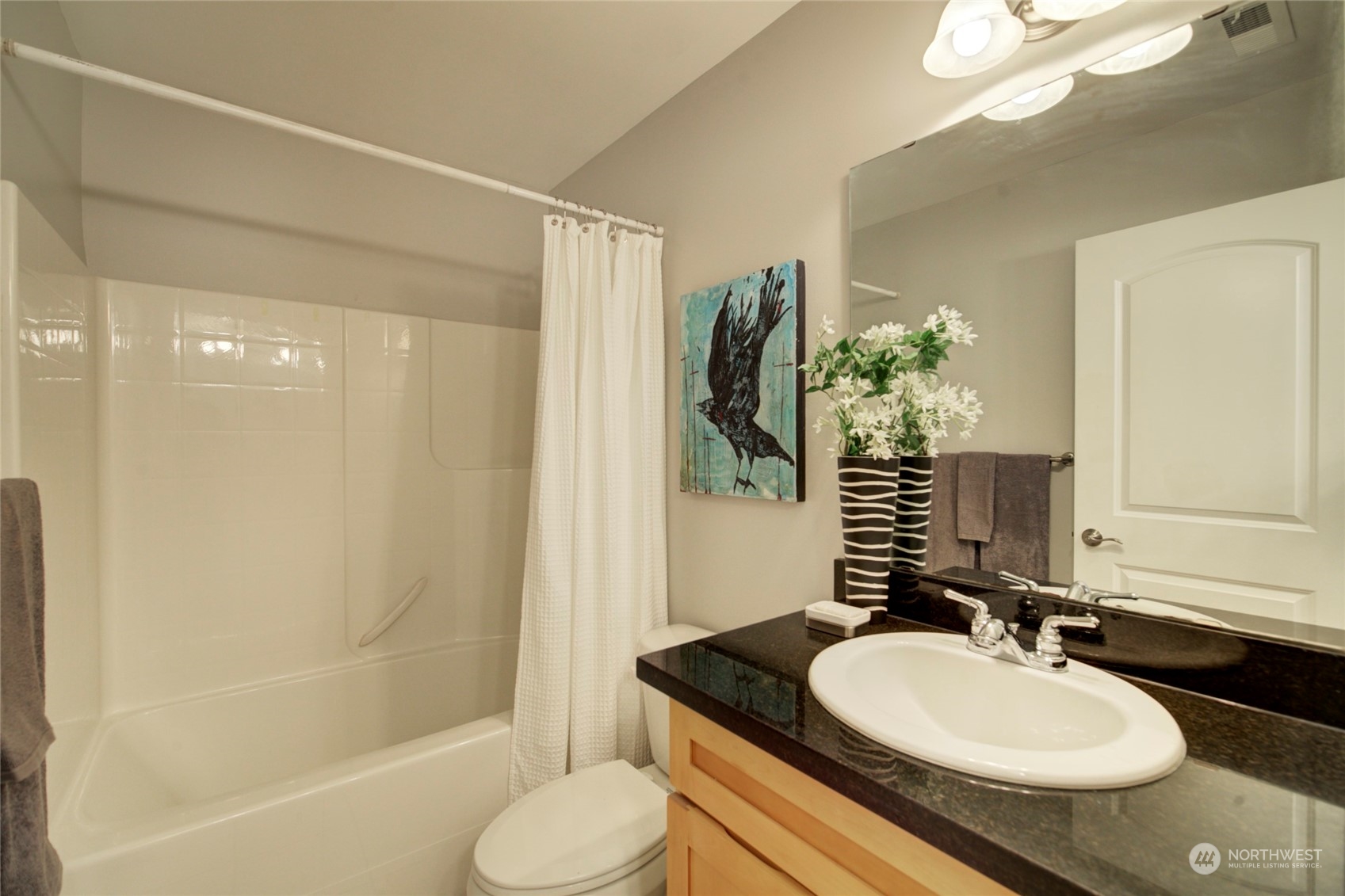 3649 22nd Avenue Southwest Seattle, WA 98106 - Photo 35 of 40 a bathroom with a granite countertop sink and a mirror