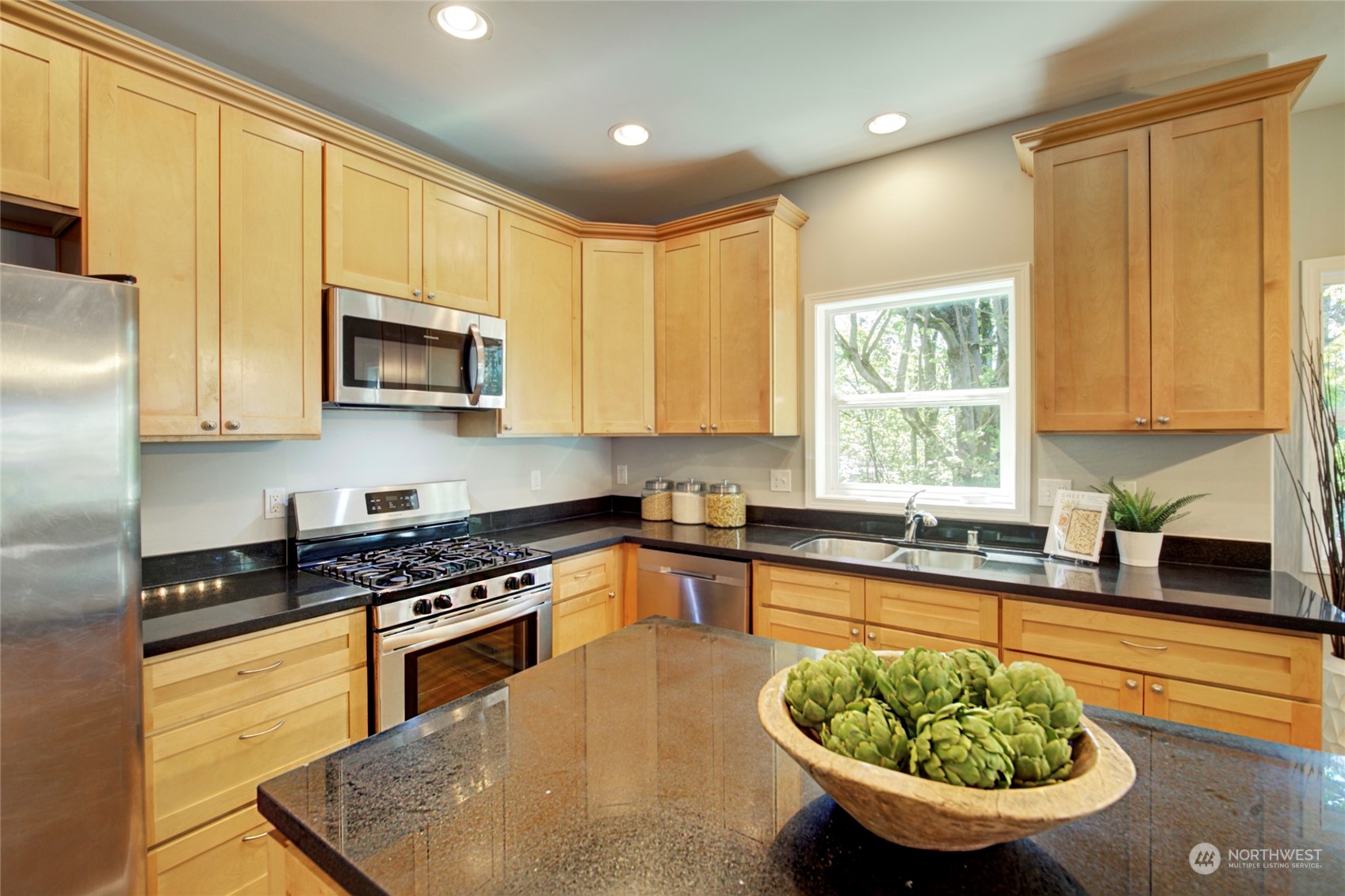 3649 22nd Avenue Southwest Seattle, WA 98106 - Photo 6 of 40 a kitchen with stainless steel appliances granite countertop a sink a stove a microwave cabinets and a window