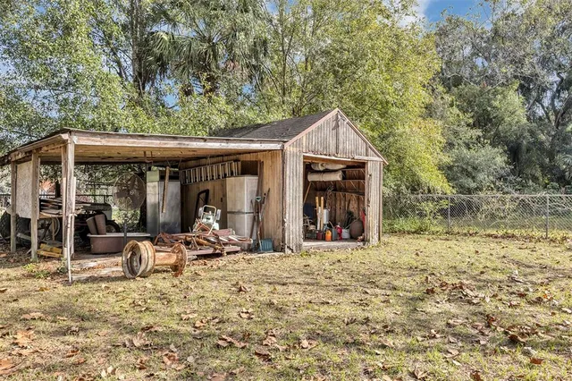 a view of a house with a yard and large trees
