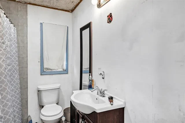 a bathroom with a sink a toilet and mirror