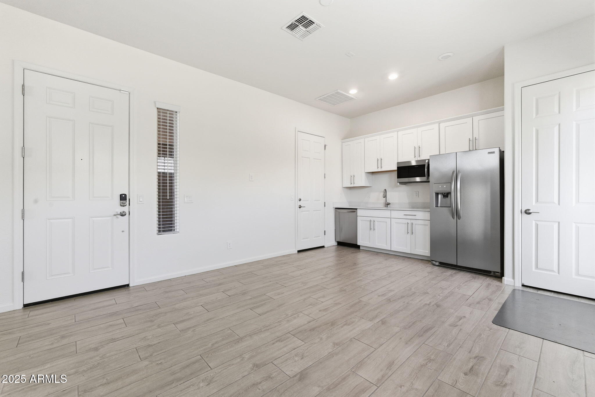 18545 West Chuckwalla Canyon Road Goodyear, AZ 85338 - Photo 21 of 26 a view of a kitchen with refrigerator and white cabinets
