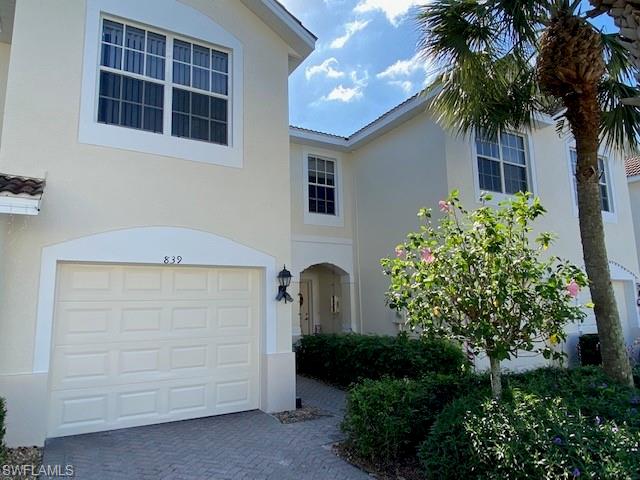 839 Hampton Circle, Unit 149 Naples, FL 34105 - Photo 2 of 32 a front view of a house with a garden