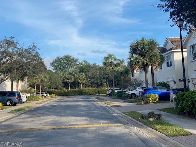 839 Hampton Circle, Unit 149 Naples, FL 34105 - Photo 24 of 32 a tall yellow building with trees in front of it
