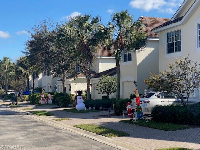 839 Hampton Circle, Unit 149 Naples, FL 34105 - Photo 28 of 32 a front view of a house with garden and trees