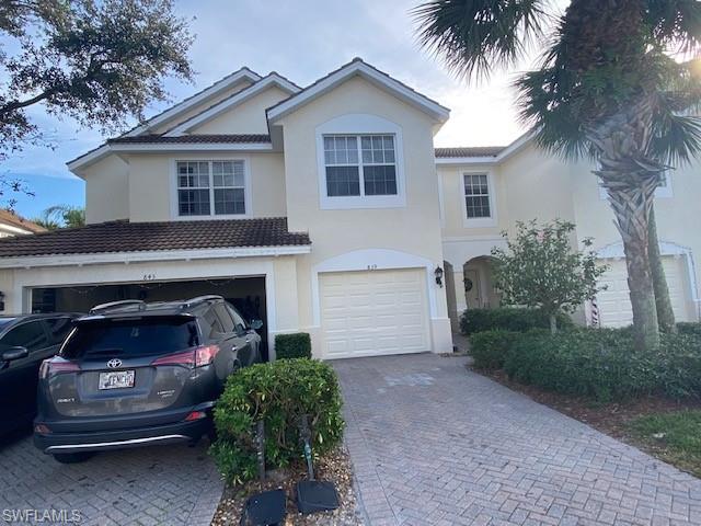 839 Hampton Circle, Unit 149 Naples, FL 34105 - Photo 3 of 32 a front view of a house with a garden