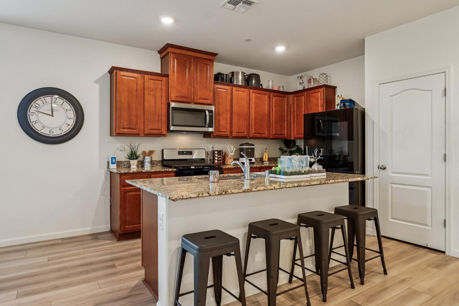 5626 Sunhaven Street Marysville, CA 95901 - Photo 11 of 31 a kitchen with stainless steel appliances granite countertop a refrigerator a stove a sink and a microwave with wooden floor