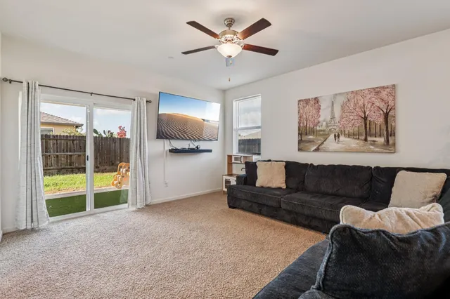 a living room with furniture and a floor to ceiling window