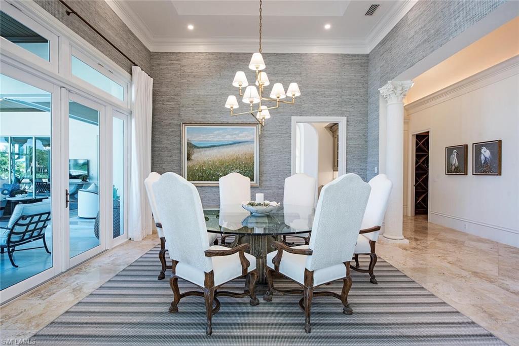 13741 Pondview Circle Naples, FL 34119 - Photo 15 of 50 a dining room with furniture a chandelier and wooden floor
