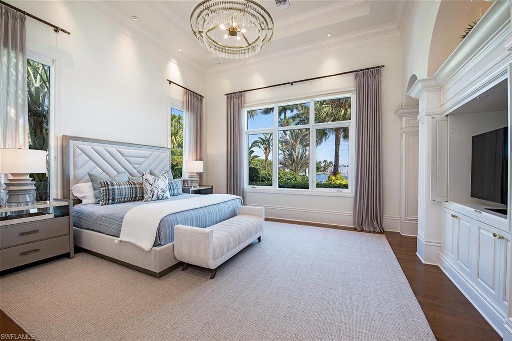 13741 Pondview Circle Naples, FL 34119 - Photo 23 of 50 a spacious bedroom with a bed and a flat tv screen on dresser