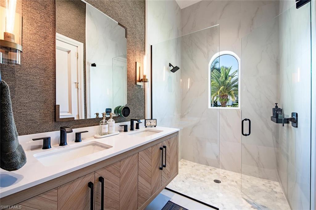 13741 Pondview Circle Naples, FL 34119 - Photo 33 of 50 a bathroom with a double vanity sink a mirror and a shower
