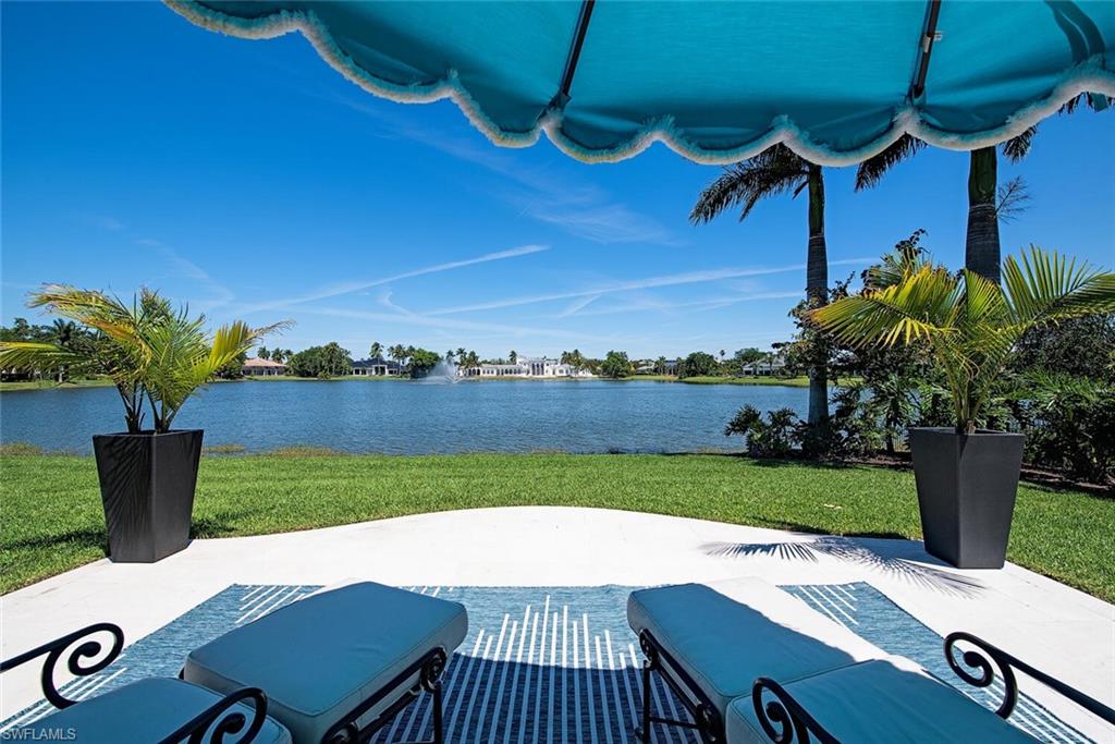 13741 Pondview Circle Naples, FL 34119 - Photo 37 of 50 a view of a patio with table and chairs potted plants with wooden floor