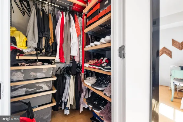 a view of walk in closet with clothes and shoes
