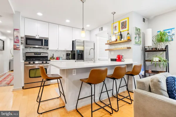 a kitchen with stainless steel appliances kitchen island granite countertop a refrigerator and microwave