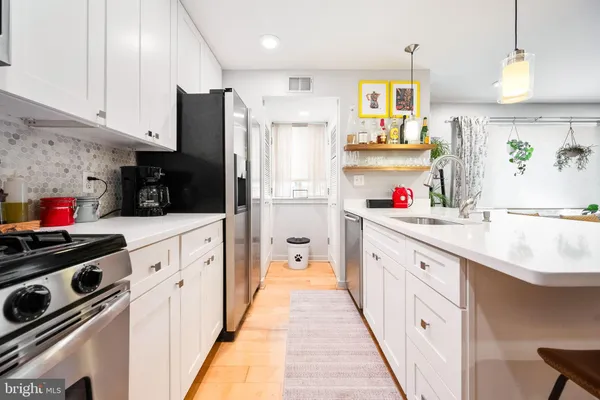 a kitchen with stainless steel appliances a sink stove refrigerator and cabinets