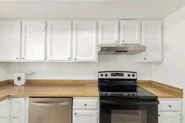 a kitchen with granite countertop white cabinets and appliances