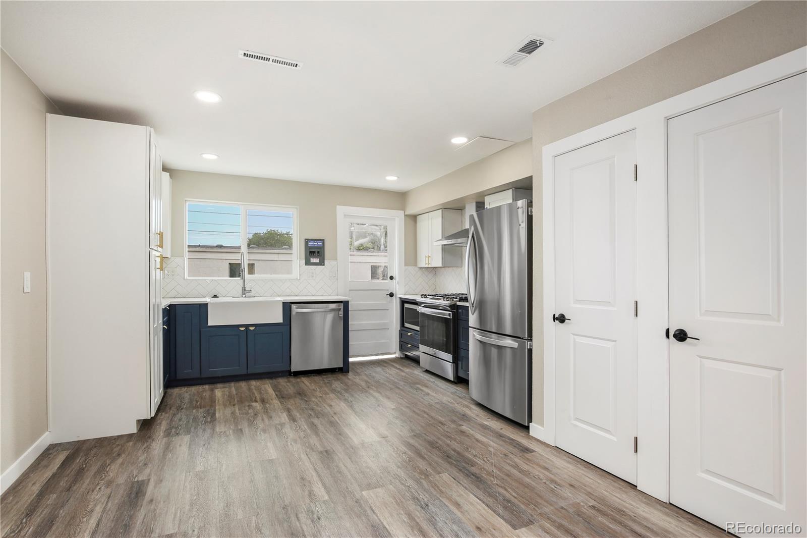4334 North Decatur Street Denver, CO 80211 - Photo 9 of 26 a large kitchen with a wooden floor and stainless steel appliances