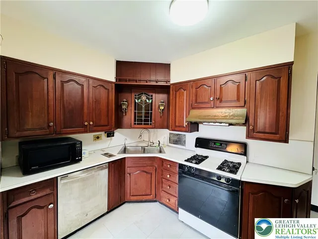 a kitchen with stainless steel appliances granite countertop a stove refrigerator and cabinets