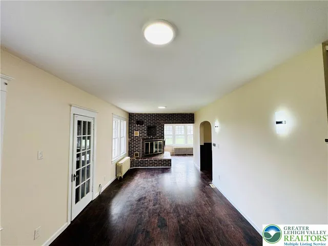 a view of a hallway with wooden floor and closet