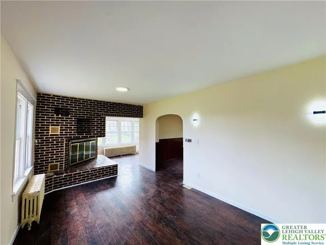a view of a livingroom with wooden floor and kitchen