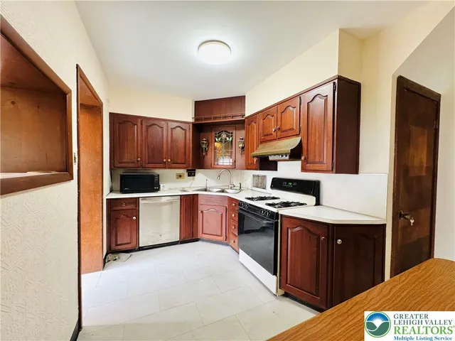 a kitchen with a sink stove top oven and refrigerator