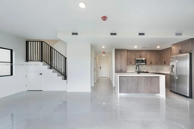a view of kitchen with furniture and stainless steel appliances