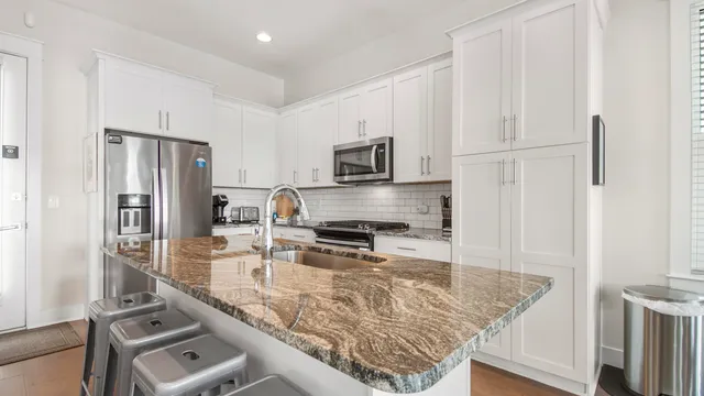 a kitchen with stainless steel appliances granite countertop a refrigerator and a stove top oven
