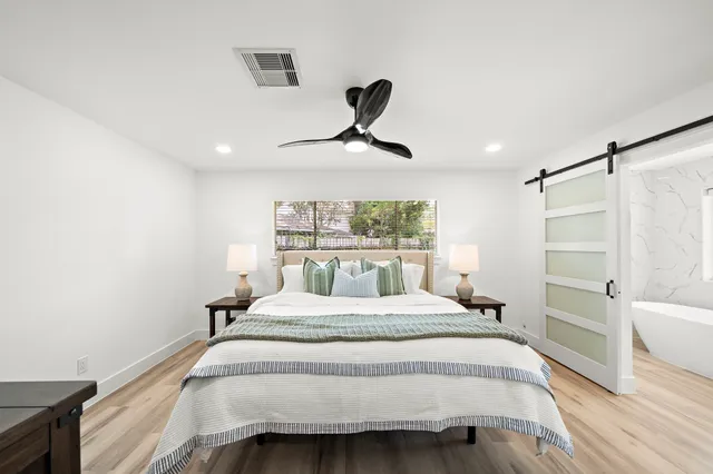 a bedroom with a bed and a chandelier