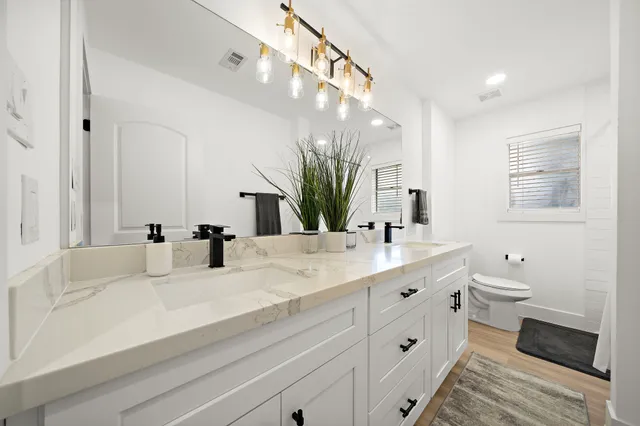 a bathroom with a sink a toilet and a mirror