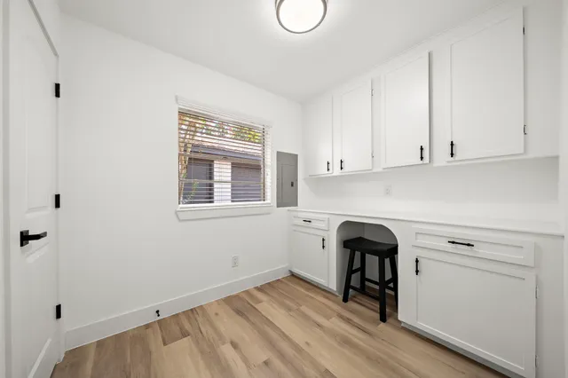a view of a kitchen with white cabinets and wooden floor