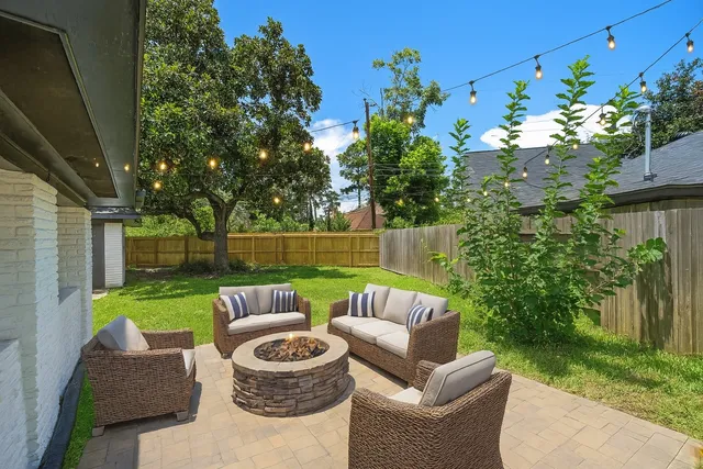 a view of a chair and table in the back yard of the house